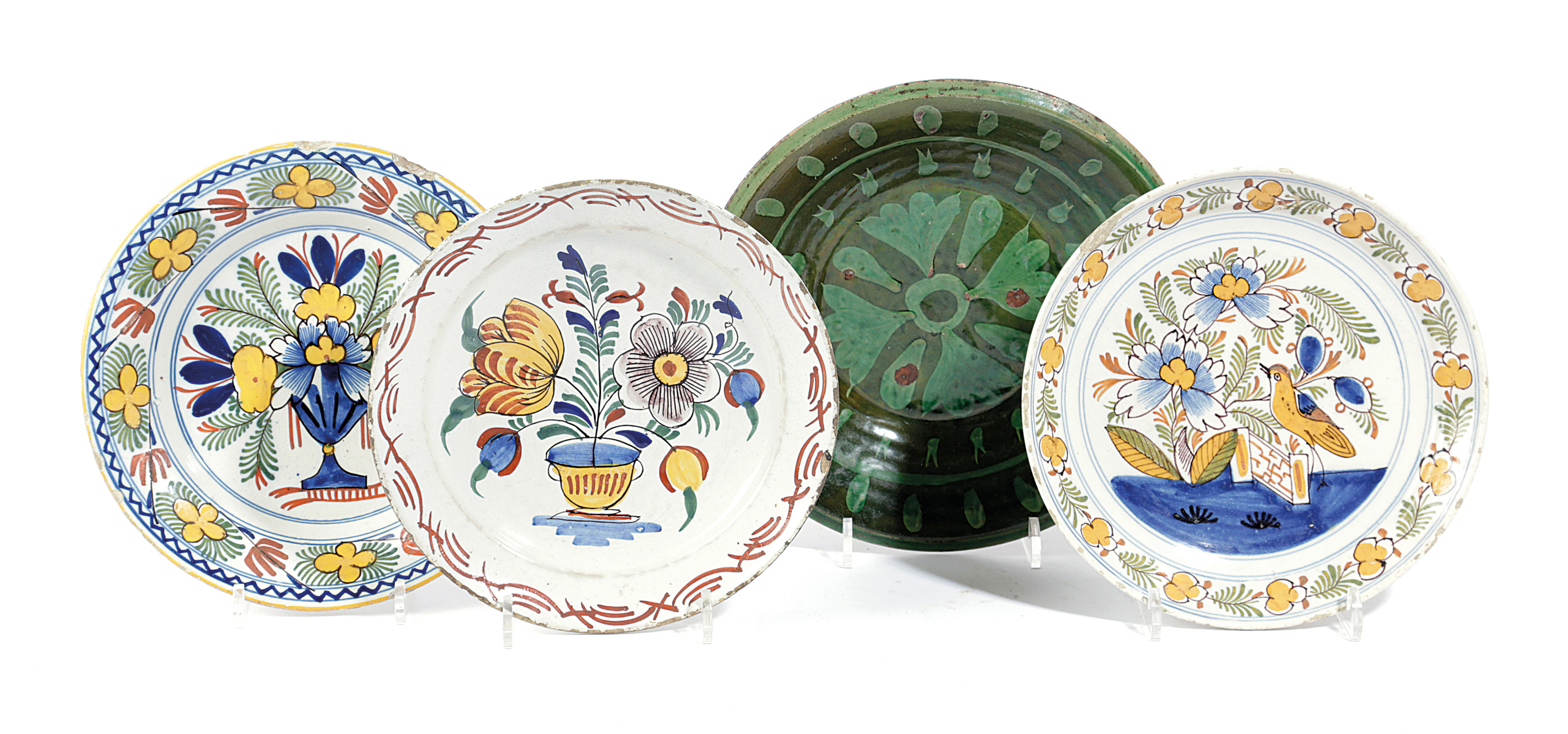 THREE DELFTWARE POTTERY PLATES 18TH CENTURY polychrome decorated with a bird on a fence, and urns of