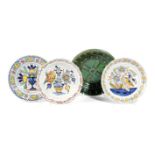 THREE DELFTWARE POTTERY PLATES 18TH CENTURY polychrome decorated with a bird on a fence, and urns of
