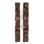 TWO SIMILAR OAK TERMS 17TH CENTURY each carved with a saint figure holding a cross, above leaves and