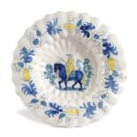 A DELFT POTTERY LOBED DISH C.1700 painted in blue and yellow, the centre with a man on horseback,