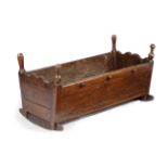 AN OAK CRADLE LATE 17TH / EARLY 18TH CENTURY inlaid with bog oak and holly bands, on curved sleigh