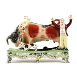 A LARGE STAFFORDSHIRE POTTERY 'BULL BEATING' GROUP LATE 19TH CENTURY the tethered bull attacked by