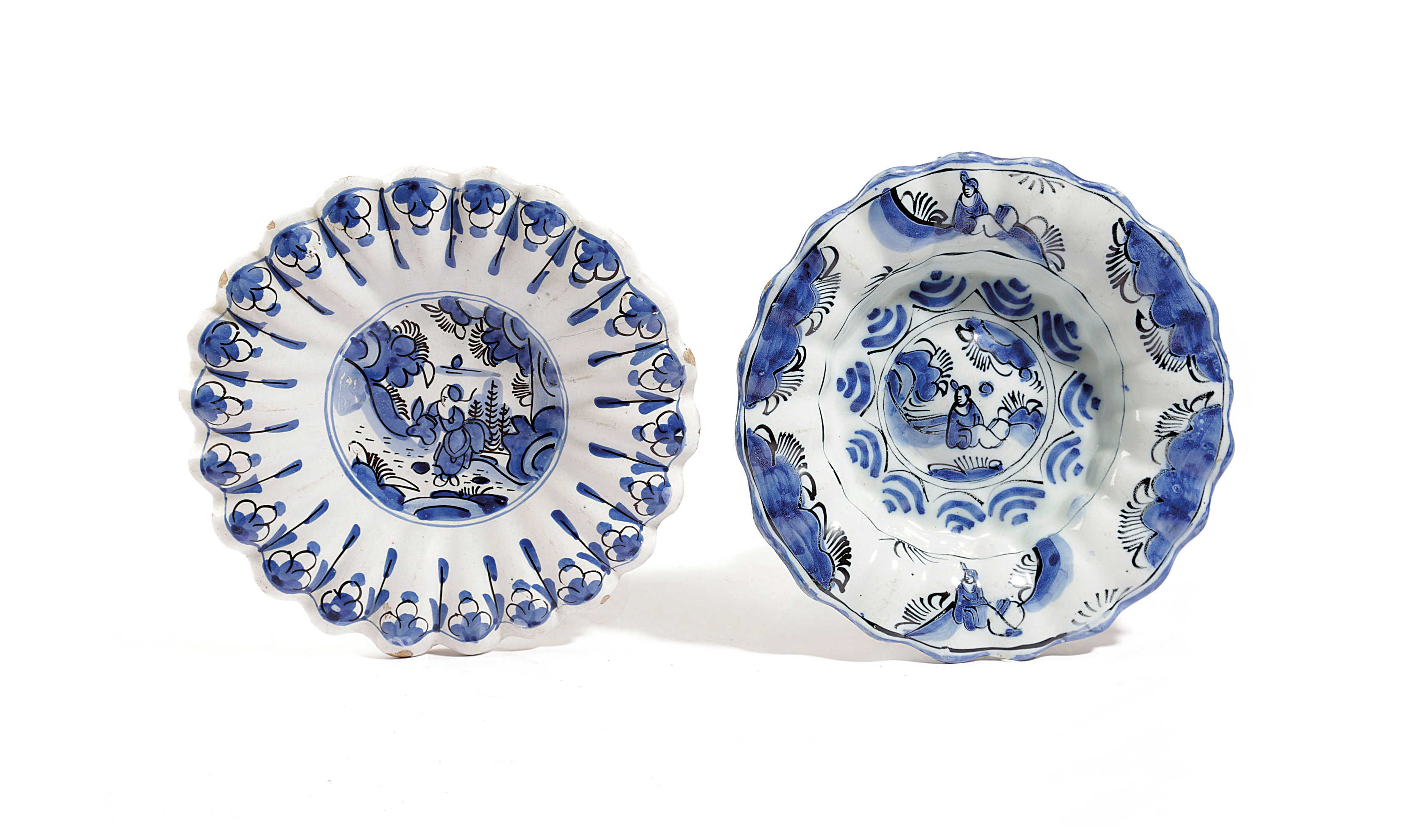 TWO DELFT POTTERY LOBED DISHES EARLY 18TH CENTURY each painted in blue and black with a seated