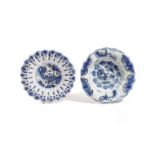 TWO DELFT POTTERY LOBED DISHES EARLY 18TH CENTURY each painted in blue and black with a seated
