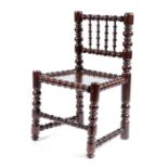 A CHARLES II YEW TURNER'S CHAIR C.1680 with a spindle back above an oak solid seat, above a bobbin