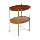 A BRASS OVAL ETAGERE MID-20TH CENTURY with two tiers inset with gilt tooled leather on faux bamboo