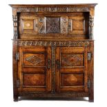 AN OAK PRESS CUPBOARD LATE 17TH CENTURY AND LATER the frieze carved with leaf lunettes with owner'