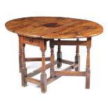 A WILLIAM AND MARY YEW GATELEG TABLE LATE 17TH CENTURY the oval drop-leaf top above an end frieze