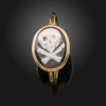 A hardstone cameo-set gold ring, the sardonyx cameo depicting a skull and crossbones, size N