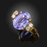 A tanzanite and diamond ring, the oval-shaped tanzanite is set with two round brilliant-cut diamonds