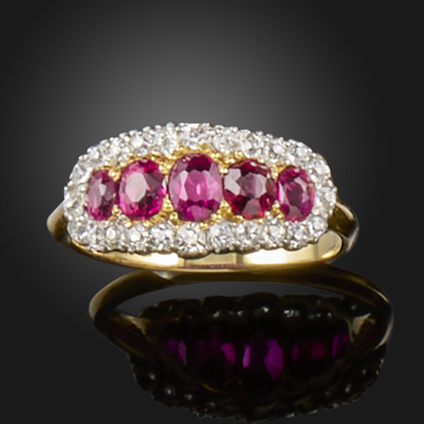 A early 20th century ruby and diamond cluster ring, set with graduated oval-shaped rubies within a