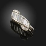 A diamond-set platinum ring, of scroll design, set with baguette-shaped and circular-cut diamonds in