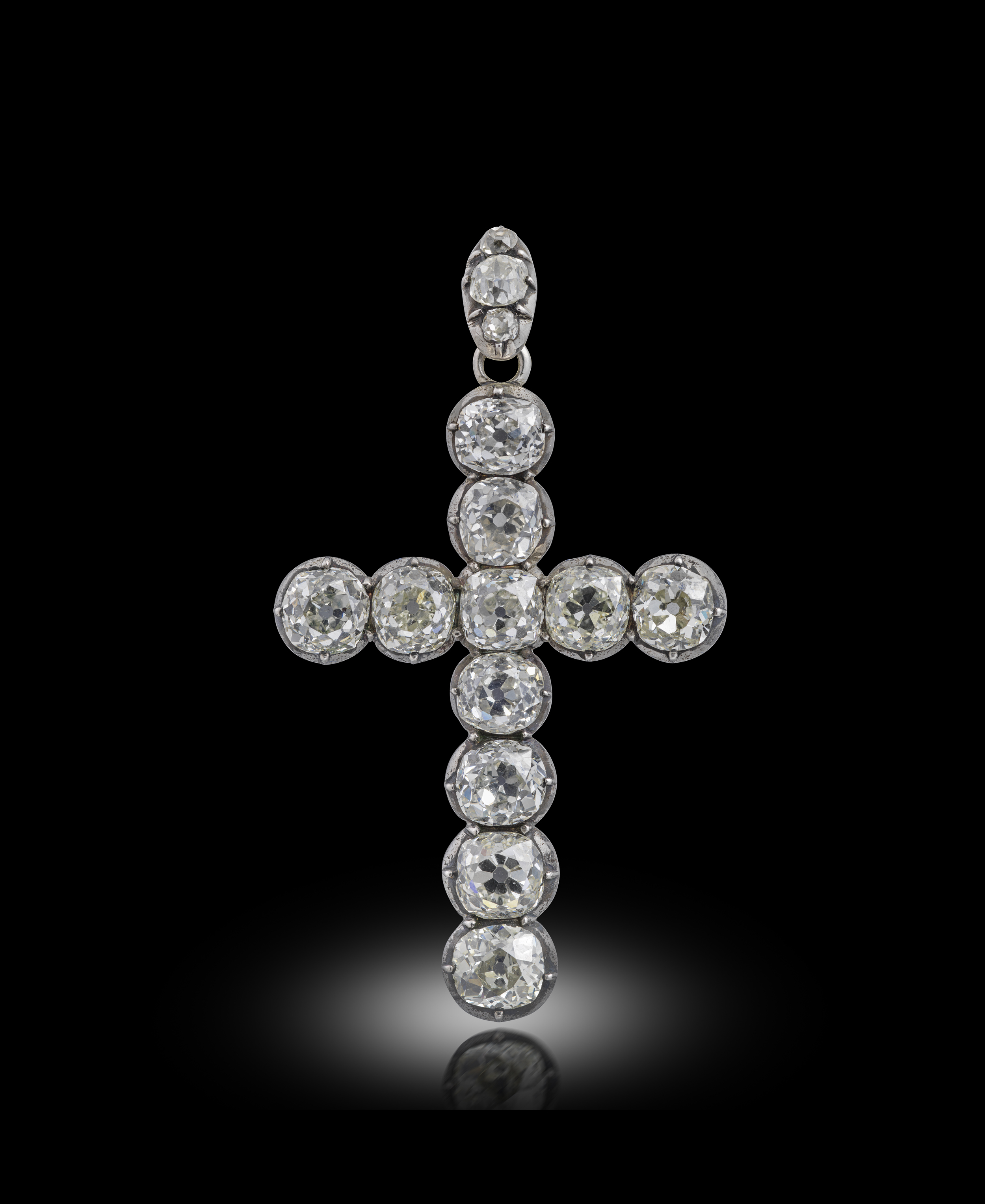 A late 19th century diamond cruciform pendant, set with eleven old cushion-shaped diamonds in silver
