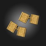 A pair of gold cufflinks by Cartier, the textured rectangular links with polished borders, signed