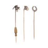Three late 19th century - early 20th century diamond-set stick pins, including a stick pin
