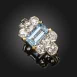 An aquamarine and diamond ring, the emerald-cut aquamarine is set with cushion-shaped diamonds to