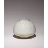 A KOREAN WHITE GLAZE FACETED JAR JOSEON DYNASTY, 19TH CENTURY The squat bulbous body raised on a