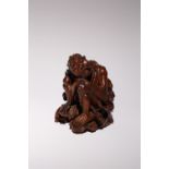 A CHINESE CARVED HARDWOOD FIGURE OF A LUOHAN 17TH/18TH CENTURY Depicted sitting, wearing loose robes