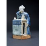 A RARE CHINESE MODEL OF A SCHOLAR EARLY 18TH CENTURY The scholar sits at his desk with his eyes