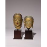 TWO BHUTANESE GILT AND POLYCHROME DECORATED POTTERY HEADS 18TH CENTURY Each depicted with a