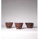 THREE CHINESE CARVED WOOD LIBATION CUPS QING DYNASTY Two carved with blossoming prunus issuing