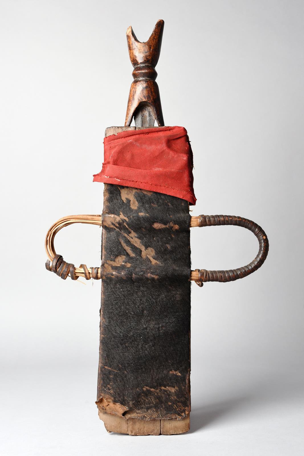 A Tikar knife Cameroon with a fullered blade and carved wood handle, in a hide and cloth covered