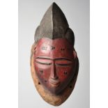 A Baule mask Ivory Coast with red and black paint, 34cm high. Provenance Collected in the 1960's