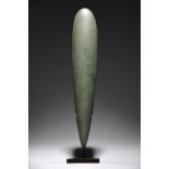 A Lake Sentani obligation stone Irian Jaya, Indonesia greenstone, 43cm long, on a stand. (2)