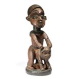 A Bamileke figure Cameroon astride a leopard, with pokerwork decoration, 52.5cm high.