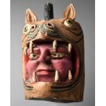 A Guerrero dance mask Mexico carved with a human face in the mouth of a pig like head with painted