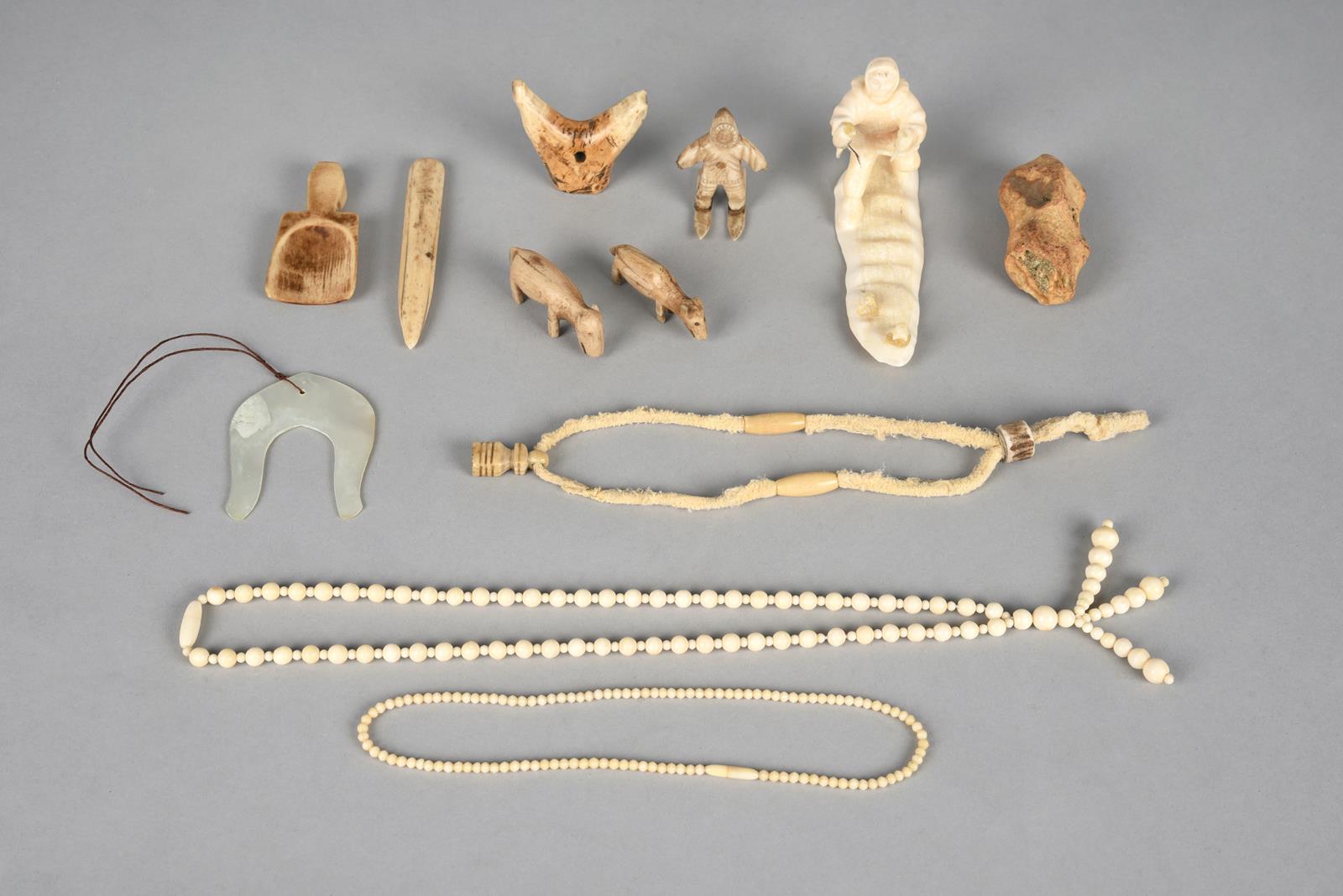 λA group of Inuit artefacts including two carved bone model caribou, 5.4cm and 5.5cm long, a