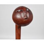 A Gogo knobkerrie Tanzania with a carved face and inset lead eyes, 66cm long.