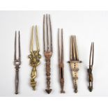 Six Indian hairpins brass and steel, including a standing female figure holding two parrots, a