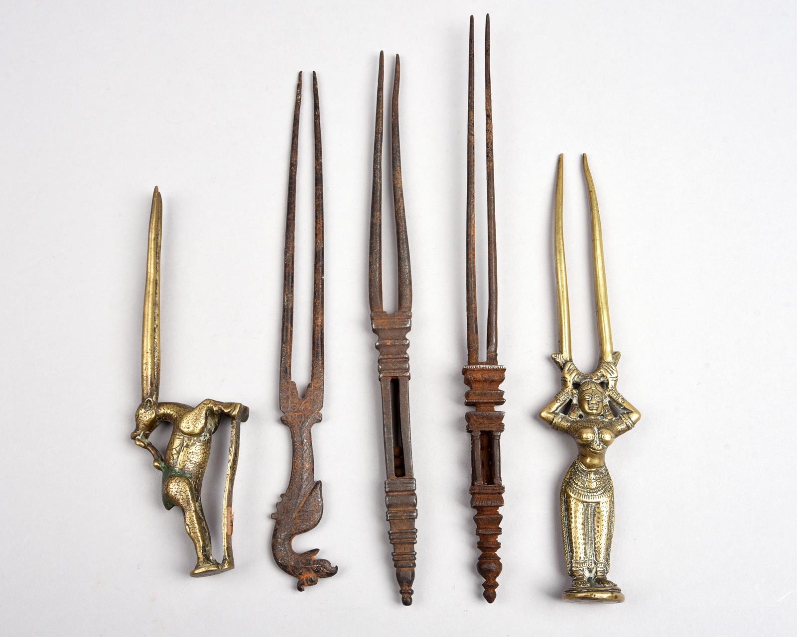 Five Indian hairpins brass and steel, all with two prongs, including a standing female figure, a