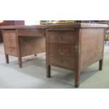 A limed oak kneehole twin pedestal desk with inset green leather panelled top over an arrangement of