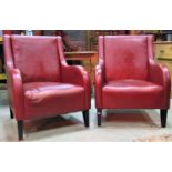 A pair of faux stitched red leather upholstered club chairs with down swept arms and square