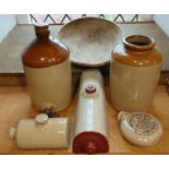 A collection of salt glazed items comprising three hot water bottles, a large jar and a tapped