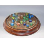 Pitched pine solitaire board with a collection of various antique marbles many with latte chino