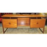 A mid 20th century G plan low and long teak dressing table fitted with four drawers beneath a raised
