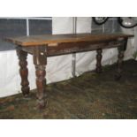 A Victorian style stained pine kitchen table with rectangular planked top raised on turned supports,