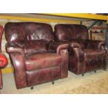 A pair of contemporary stitched brown leather reclining armchairs with soft pad arm cushions