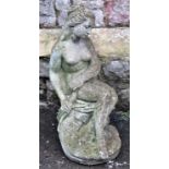 A weathered contemporary cast composition stone garden ornament in the form of a seated classical