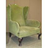 A Georgian style wing armchair with green dralon upholstered finish and squat cabriole forelegs