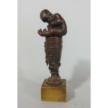 Good quality bronze seal in the form of a nude child on top of a baluster wine urn, 10 cm high
