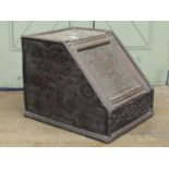 An antique oak box / coal scuttle with repeating carved floral detail