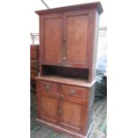 A vintage stained pine kitchen dresser, freestanding and enclosed by an arrangement of four doors