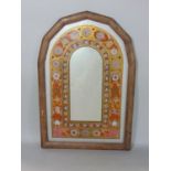 A decorative wall mirror in the form an arched window with foliate running borders, 48 cm x 33 cm
