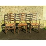 A pair of dark stained Ercol elm and beechwood ladderback carver chairs with slatted seats