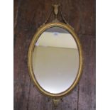 A Georgian wall mirror, the oval mirror plate within a gilded frame with repeated beaded detail