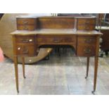 A reproduction mahogany writing desk in the Georgian manner with five frieze drawers raised on